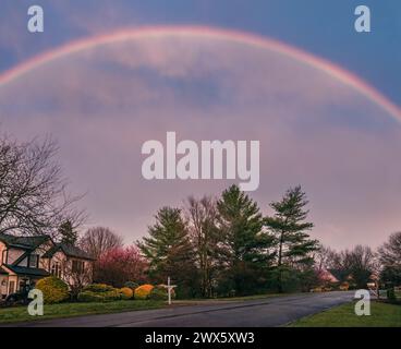 Wunderschöner Blick auf den Regenbogen über die Vorstadtstraße im Mittleren Westen im Frühjahr nach Regen Stockfoto