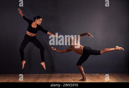Tänzer, dramatisch und Performance im Studio mit dunklem Hintergrund, männliche und weibliche Ballerina sind kreativ zusammen. Leichtathletik, Wettkampf und Sport Stockfoto
