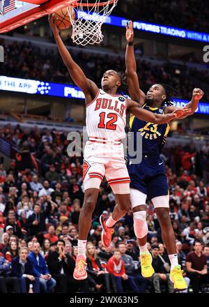 Chicago, USA. März 2024. Chicago Bulls’ Ayo Dosunmu (L) fährt während des regulären NBA-Saisonspiels zwischen Indiana Pacers und Chicago Bulls in Chicago, USA, am 27. März 2024 in den Korb. Quelle: Joel Lerner/Xinhua/Alamy Live News Stockfoto