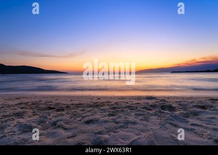 Ein wunderschöner Sonnenaufgang am Strand mit Leuchtturm hinten. Skala Potamias, Thassos, Griechenland Stockfoto