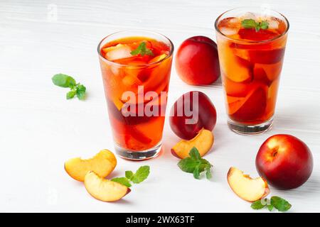 Pfirsich Eistee in ein Glas mit Minze auf eine weiße Holztisch (selektive Fokus). Stockfoto