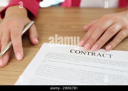 Weibliche Führungskraft bittet die Kundin, den Vertrag in ihrem Büro zu unterzeichnen. Stockfoto