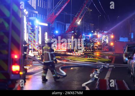 Vier Tote bei Brandanschlag in Solingen in den frühen Morgenstunden 25.03.2024, 02:45 Uhr, kam es zu einem folgenschweren Brand in Solingen. Mehrere Anwohner meldeten das Feuer in einem Mehrfamilienhaus an der Grünewalder Straße. Während der Löscharbeiten versorgte der Rettungsdienst neun Bewohner, die unterschiedlich schwere Verletzungen erlitten. Die Feuerwehr muss zunächst drei Leichname aus dem Gebäude bergen. Ein weiterer Leichnam wurde nach Suchmaßnahmen gegen 13:15 Uhr geborgen. Das Brandhaus sowie danebenstehende Gebäude sind derzeit nicht bewohnbar. Um die Ermittlungsarbeit zu unter Stockfoto