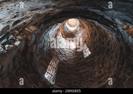 Ein tiefer Blick in das Innere des Aussichtsturms von Krasno, der die kreisförmige Steinarchitektur und die aufsteigende Perspektive zeigt. Stockfoto