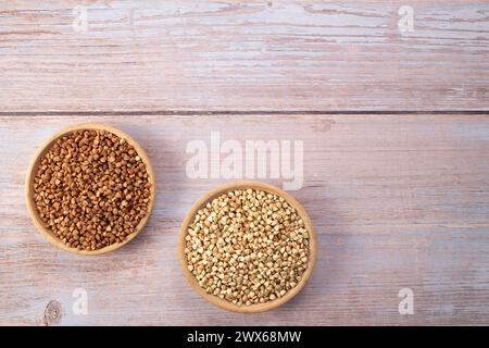 Grüne und frittierte Buchweizenkörner in der Holzschale. Gesundes vegetarisches Lebensmittelkonzept Stockfoto