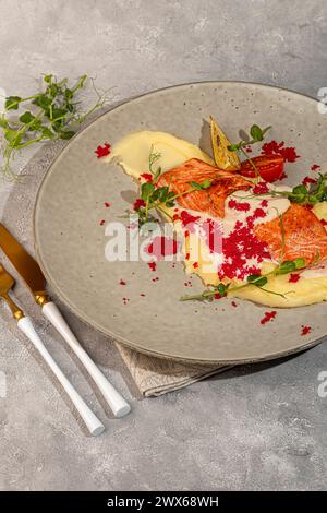 Lachs mit Kartoffelpüree, belegt mit weißer Sauce und garniert mit Kaviar und Erbsensprossen. Kopierbereich Stockfoto