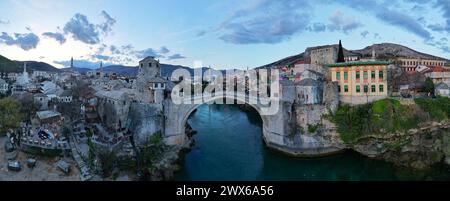 Panoramablick auf die Alte Brücke in Mostar in Bosnien und Herzegowina. Fluss Neretva. Unesco-Weltkulturerbe. Leute, die über die Brücke laufen Stockfoto