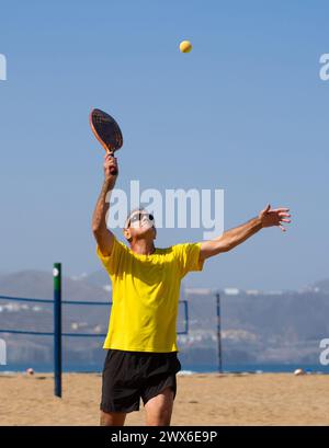 Mann über 60 Jahre, der Strandtennis spielt. Seniorenmann mit gesundem Lebensstil Stockfoto