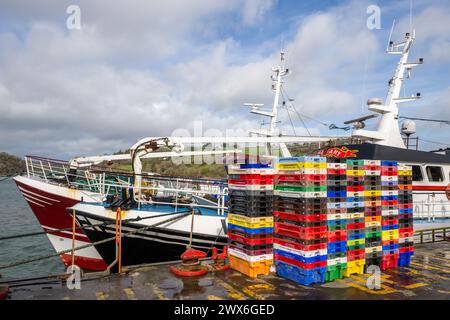 Leere Fischkisten stapelten sich am Kai am Keelbeg Pier, Union Hall, West Cork, Irland. Stockfoto