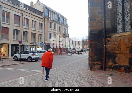 Colmar, Frankreich - 21. Dezember 2023: Alter Mann in der Nähe der St. Martin-Kirche. Altstadt. Weihnachten Stockfoto