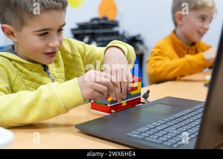 Aufgeregt Kinder bauen in der Schule einen Roboter Stockfoto