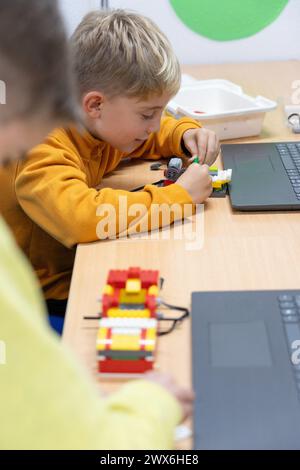 Kinder lernen, wie sie einen Roboter bauen und programmieren, in einem Robotik-Kurs für Kinder Stockfoto