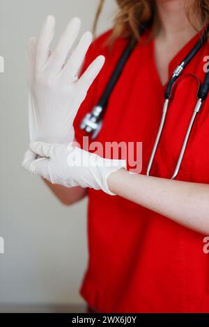 Ärztin, die medizinische Handschuhe in der Klinik anzieht, Nahaufnahme Stockfoto