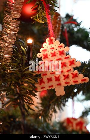 Handgefertigtes, perlenbesetztes Pixel-Art-Weihnachtsbaumschmuck mit Kreuzstickerei. Gemischte Techniken, Schmelzperlen mit rotem Baumwollgarn. Stockfoto