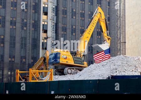 Ein Bagger und eine amerikanische Flagge auf Bauschutt am Abbruchort für das neue Gefängnis in Downtown Manhattan, New York City. Stockfoto