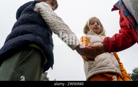 Ein Team von Kindern, die Hände zusammenlegen Stockfoto