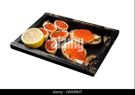 Toast und Tartlets mit rotem Kaviar und Butter in Holztablett. Isoliert auf weißem Hintergrund. Draufsicht Stockfoto