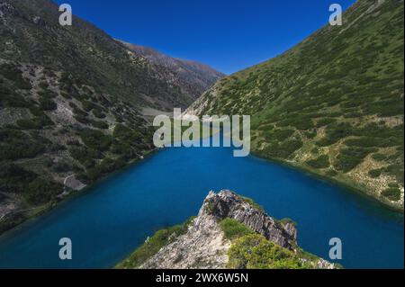 Panoramalandschaft mit blauem See in den Bergen im Sommer. Koksai Ainakol See im Tien Shan Gebirge in Asien in Kasachstan Stockfoto