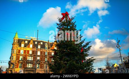 Erkunden Sie den Charme und das architektonische Erbe Amsterdams durch seine lebhaften Straßen, wo ikonische Gebäude ein malerisches Stadtbild prägen. Stockfoto