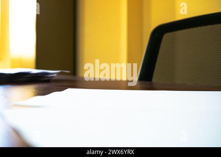 Ein makelloser Schreibtisch mit ordentlich gestapelten weißen A4-Papieren schafft einen organisierten und effizienten Arbeitsplatz für professionelle Zwecke. Stockfoto