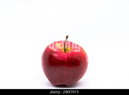 Ein Rotapfelboden bietet eine lebendige, saftige Frucht, isoliert auf einem sauberen weißen Hintergrund, verkörpert Frische und Gesundheit. Stockfoto