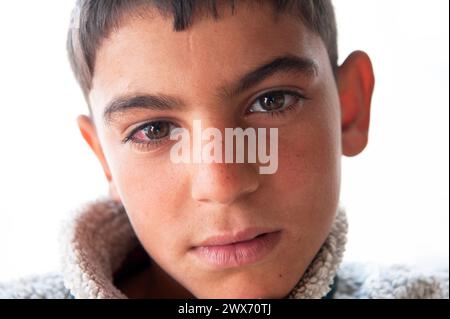 Flüchtlingscamp Al Za atari, Jordanien etwa 14 Jahre alter Teenager, der vor dem Bürgerkrieg in Syrien geflohen ist und jetzt das zweite große Flüchtlingslager der Welt durchstreift, traumatisiert von dem, was er in seiner Heimat gesehen hat. Al Za atari, Al Mafraq, Jordanien, Naher Osten. Mafraq Refugeecamp Al Za atari, Jordan Al Mafraq Jordan Copyright: XGuidoxKoppesx Stockfoto