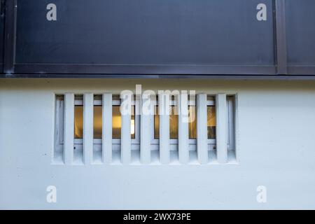 Licht hinter modernen Fenstern in Betonwand Stockfoto