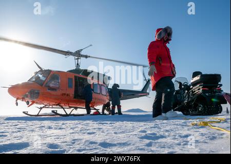 Personal lädt Ausrüstung auf einen Bell UH-1H Hubschrauber während der Operation Ice Camp bei Ice Camp Whale, nahe Prudhoe Bay, Alaska, 18. März 2024 Stockfoto