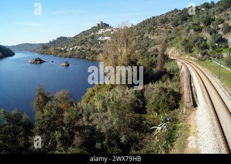 Fluss Tejo, mit der Eisenbahn am rechten Ufer, auf einem Hügel gelegene mittelalterliche Burg von Belver mit Blick auf die Landschaft im Hintergrund, Belver, Portugal Stockfoto