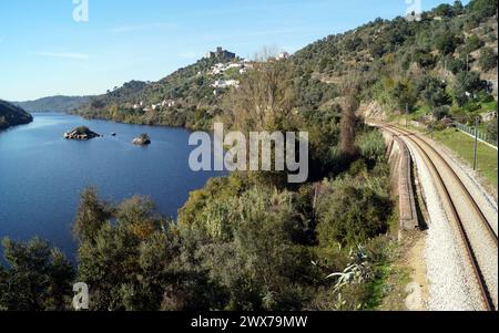 Fluss Tejo, mit der Eisenbahn am rechten Ufer, auf einem Hügel gelegene mittelalterliche Burg von Belver mit Blick auf die Landschaft im Hintergrund, Belver, Portugal Stockfoto