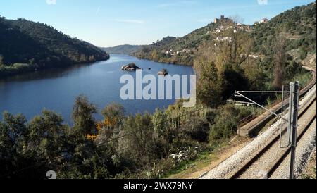 Fluss Tejo, mit der Eisenbahn am rechten Ufer, auf einem Hügel gelegene mittelalterliche Burg von Belver mit Blick auf die Landschaft im Hintergrund, Belver, Portugal Stockfoto