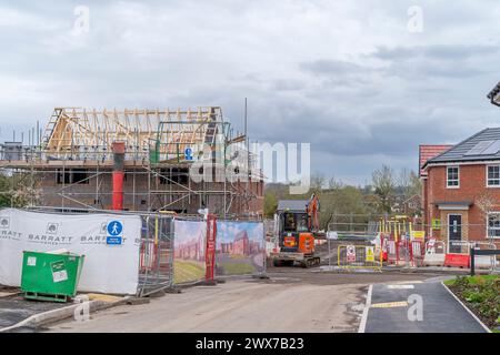 Eine Wohnsiedlung von Barratt Homes im Bau mit teilweise gebauten Häusern mit Gerüsten und Barrieren. Stockfoto