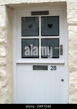 Hübsches 'Sweetheart Cottage' weiße vordere Stalltür eines Hauses mit Herzformen auf geätzten Glasfenstern und Nummer 28 Plakette, St Ives, Cornwall, Großbritannien Stockfoto