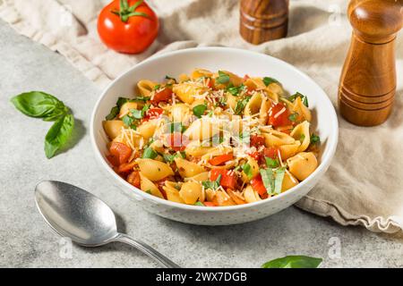 Italienische hausgemachte Chonchiglie-Pasta mit Tomaten und Basilikum Stockfoto