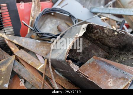 Auf einem Nahfoto wird ein verlassener Metallabfall auf einem Schrottplatz dargestellt, der den industriellen Verfall und die Vernachlässigung beschreibt, die für solche Umgebungen charakteristisch sind. Stockfoto