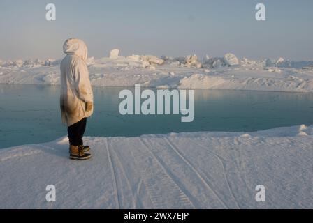 Ein Inupiaq-Existenzjäger steht auf rauem Packeis, nachdem er unweit der Küste, der Chukchi-See Alaska, instabile Meereisbedingungen beobachtet hat Stockfoto