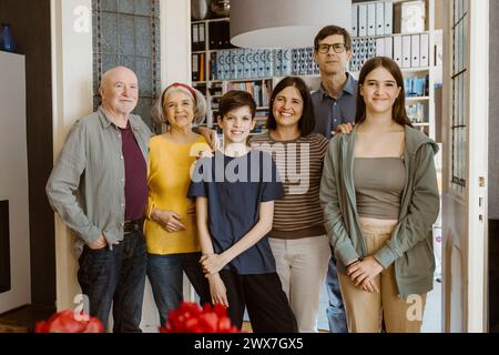 Porträt einer lächelnden Familie mehrerer Generationen, die zu Hause zusammen steht Stockfoto