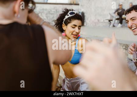 Nicht-binäre Person, die mit Freunden auf einer Party tanzt Stockfoto