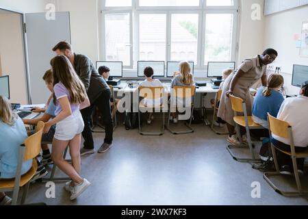 Lehrerunterrichtsgruppe männlicher und weiblicher Schüler im Computerunterricht in der Schule Stockfoto