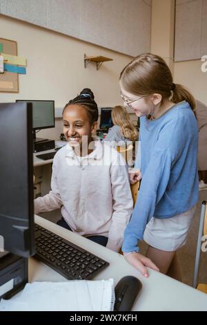 Glückliche multirassische Mädchen, die Spaß im Computerunterricht in der Schule haben Stockfoto