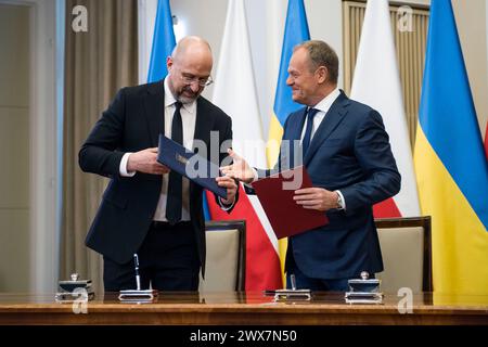 Warschau, Polen. März 2024. Der ukrainische Premierminister Denys Smyhal (L) und Ministerpräsident Donald Tusk (R) unterzeichnen bilaterale Abkommen in Warschau. Der polnische Premierminister Donald Tusk und der ukrainische Premierminister Denys Shmyhal unterzeichneten Abkommen, während die polnische und die ukrainische Regierung Gespräche führen, um eine Sackgasse im Handel zu beenden, wobei die polnischen Bauern wütend über den Zustrom ukrainischer Nahrungsmittel und Agrarprodukte sind, die sie für die Verletzung ihres Geschäfts verantwortlich machen. Die Premierminister sprachen auch über eine starke Unterstützung und wie die Ukraine im Krieg gestärkt werden kann. Quelle: SOPA Images Limited/Alamy Live News Stockfoto