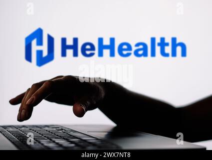 In dieser Abbildung ist das HeHealth-Logo im Hintergrund einer Silhouette einer Person zu sehen, die ein Notizbuch verwendet. Stockfoto