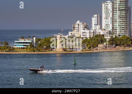 Cartagena, Kolumbien - 24. Januar 2024: Schnellboot vorbei am Naval Club und Leuchtturm am Eingang zum Hafen der Stadt Stockfoto