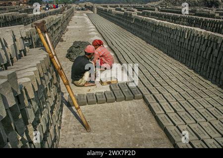 Ein Arbeiter trägt Ziegelsteine bei Maurer in Khulna, Bangladesch. Stockfoto