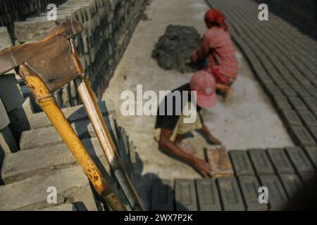 Ein Arbeiter trägt Ziegelsteine bei Maurer in Khulna, Bangladesch. Stockfoto