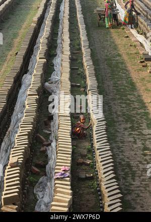 Ein Arbeiter trägt Ziegelsteine bei Maurer in Khulna, Bangladesch. Stockfoto