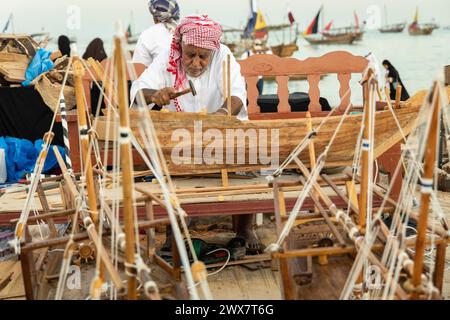 Ein kreativer Künstler, der ein kleines Modell eines traditionellen arabischen Fischerbootes baut. Stockfoto