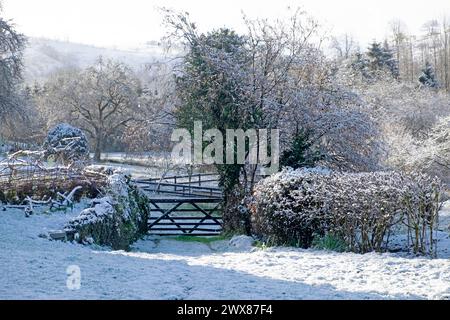 Schneebedeckte Wintervormittagsszene mit Blick auf die Landschaft durch ein hölzernes Tor im ländlichen Garten März 2024 Carmarthenshire Wales UK KATHY DEWITT Stockfoto