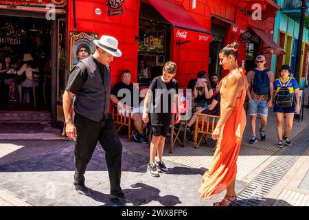 Zwei Tangotänzer zeigen Einem Jungen wie man den Tango vor Einem Café im farbenfrohen La Boca Viertel von Buenos Aires, Argentinien. Stockfoto