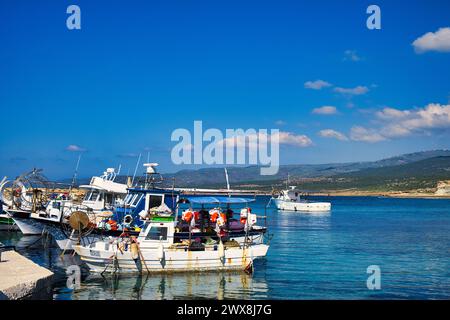 Kleine Fischerboote im Hafen von Agios Georgios am Kap Drepanum, Bezirk Paphos, Zypern. Im Hintergrund die Hügel der Halbinsel Akamas Stockfoto